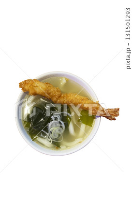 Traditional Japanese udon noodle soup served with crispy shrimp tempura, wakame seaweed, and sliced green onion in a savory broth. Traditional Japanese udon noodle soup served with crispy shrimp tempura, wakame seaweed, and sliced green onion in a savory broth. 131501293