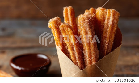 Churros With Cinnamon Sugar In Paper Cone And Chocolate Sauce. Delicious Spanish Dessert For Snacking 131501626