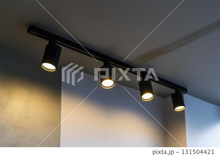Lighting equipment on the wall in the living room. Spotlights under the ceiling. Track LED-lighting system Lighting equipment on the wall in the living room. Spotlights under the ceiling. Track LED-lighting system 131504421