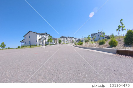 Street-level view of a newly developed residential area with identical homes stretching into the distance. Clear skies and minimal landscaping indicate a recently completed housing development. 131504479