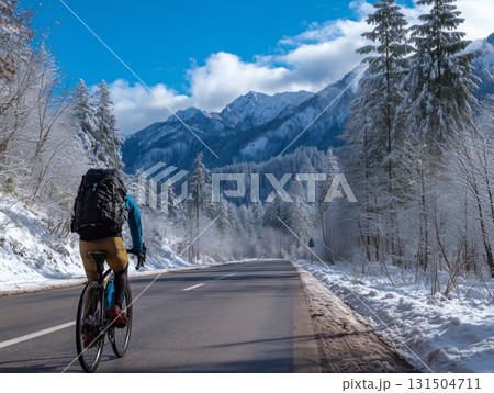 雪景色の中の舗装された道路を走るサイクリストの冬のサイクリング冒険の画像 131504711