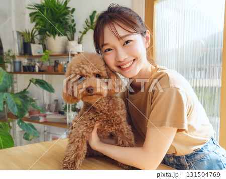 トリミングサロンで可愛いトイプードルを抱きしめる笑顔の女性ペットグルーミング 131504769