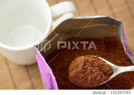 Coffee powder on spoon near empty cup. Making coffee at home 131507745