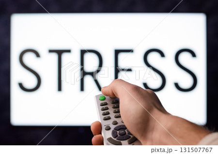Man with remote controller pressing green button. Symbol of having stress in everyday situations Man with remote controller pressing green button. Symbol of having stress in everyday situations 131507767