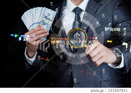 Businessman examining cash at night with city lights in background. Businessman examining cash at night with city lights in background. 131507831