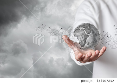 Creative hands holding a digital globe in stormy sky. 131507832
