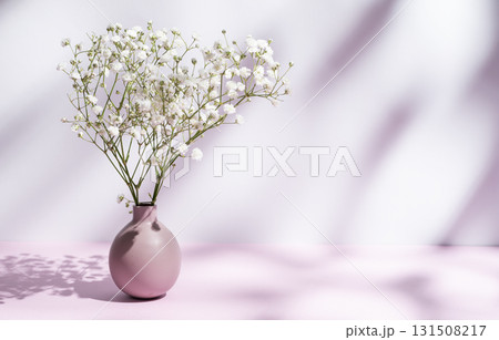 Delicate white gypsophila flowers in a lilac vase on a pink pastel background with sunny shadows. Delicate white gypsophila flowers in a lilac vase on a pink pastel background with sunny shadows. 131508217