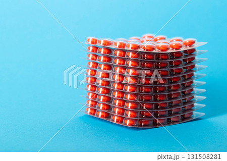 Stack of pills blisters with red pills on blue background. Concept of rifamycin antibiotics in the treatment of diseases. Copy space for text 131508281