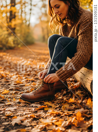 A young woman tying her boots on a forest path 131509181