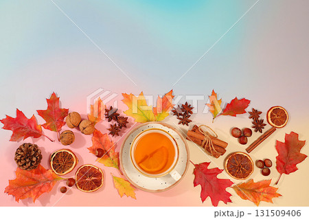 Autumn abstract composition with cup of tea or mulled wine, maple leaves, pine cones, nuts, cinnamon, star anise and dried oranges, still life and Thanksgiving concept, seasonal background and banner 131509406