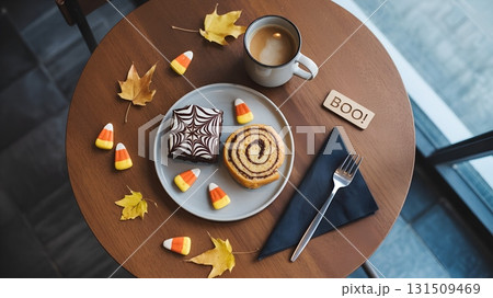 Halloween treats on a coffee table with autumn leaves, top-down flat lay with candy, and festive decor 131509469