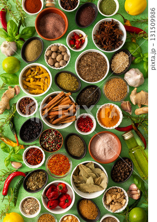 Brightly colored spices and herbs arranged on a delicate green background, highlighting their freshness and fragrance for a lively, natural look 131509986