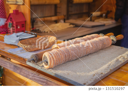 Traditional East Europe Christmas sugar dessert chimney cake, trdlo or trdelnik, sweet aromatic winter seasonal street food with cinnamon and spices 131510297