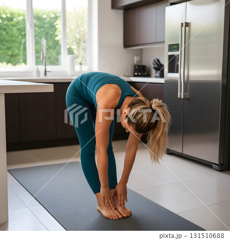 Woman Doing Standing Forward Fold Stretch in a Kitchen Woman Doing Standing Forward Fold Stretch in a Kitchen 131510688