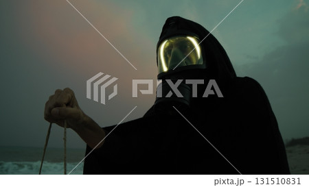 Man With Gas Mask In Radiation Contaminated Nuclear Site At Night 131510831