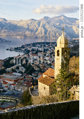 Panoramic view of the Bay of Kotor: an old bell tower against the backdrop of the city and mountains 131511366