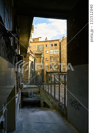 Dark Urban Passage Opening to a Neglected Inner-City Courtyard and Gritty Apartment Building Dark Urban Passage Opening to a Neglected Inner-City Courtyard and Gritty Apartment Building 131512840