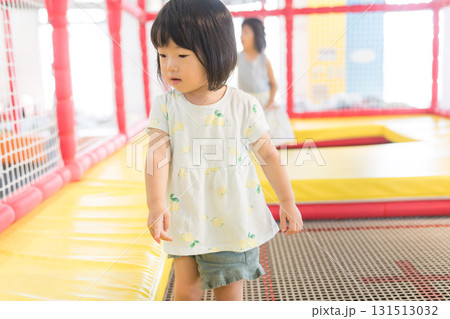 トランポリンで遊ぶ女の子の幼児 トランポリンで遊ぶ女の子の幼児 131513032