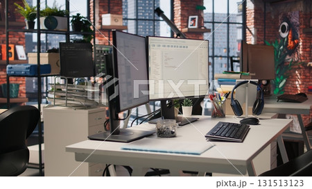 PC screens in innovative startup office showing programming languages used to build applications. Empty software development agency used for optimizing code on computers, handheld camera shot PC screens in innovative startup office showing programming languages used to build applications. Empty software development agency used for optimizing code on computers, handheld camera shot 131513123