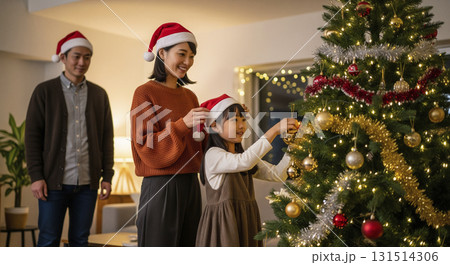 クリスマスツリーの飾り付けをする家族 131514306