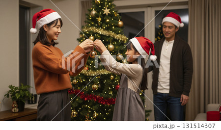 クリスマスツリーの飾り付けをする家族 131514307