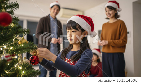 クリスマスツリーの飾り付けをする家族 131514308