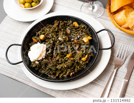 Traditional Valencian paella Arroz negro with squid ink served with aioli 131514992
