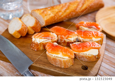 Sandwiches with smoked salmon and butter on wooden board Sandwiches with smoked salmon and butter on wooden board 131515049
