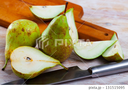 Ripe pears and knife on wooden cutting board Ripe pears and knife on wooden cutting board 131515095