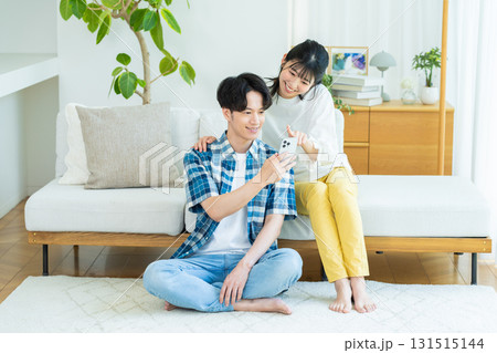 リビングでスマホを見るカップル 131515144