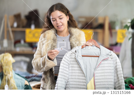 During November sales, young woman choose and buy down coat 131515166