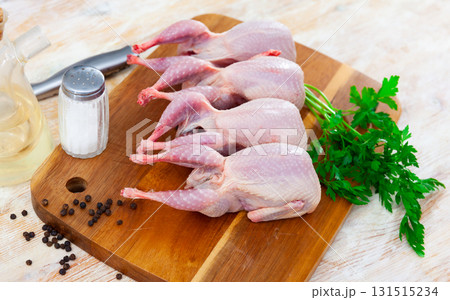 Quail carcasses lie on cutting board. Small birds are prepared for cooking Quail carcasses lie on cutting board. Small birds are prepared for cooking 131515234