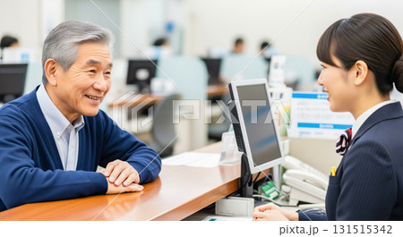銀行の窓口で相談をするシニア世代の男性 131515342