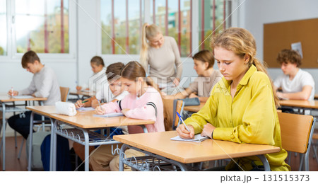 Young boys and girls studying in classroom 131515373