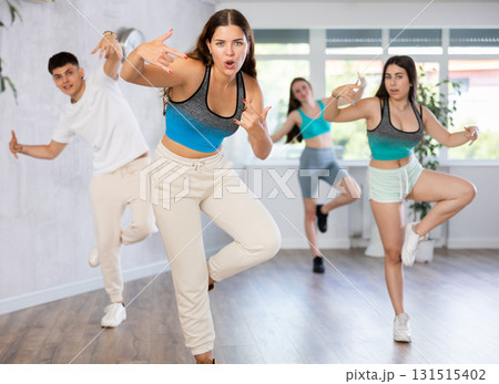 Girl teen perform choreographic exercise and teach energetic mobile social dance groove with friends Girl teen perform choreographic exercise and teach energetic mobile social dance groove with friends 131515402