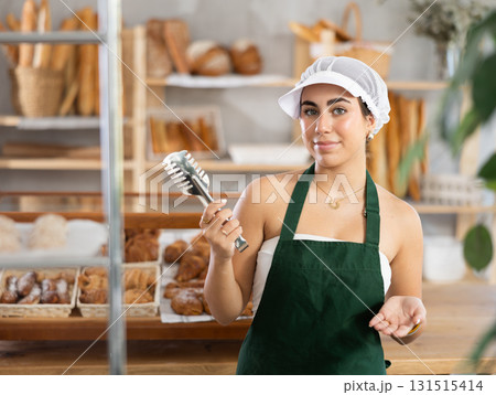 Young saleswoman holding a service clip ready to serve customers Young saleswoman holding a service clip ready to serve customers 131515414