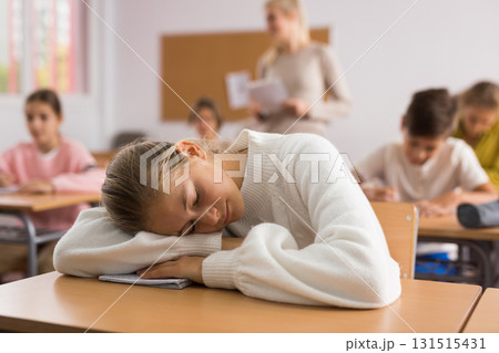 School girl lying and sleeping at desk 131515431