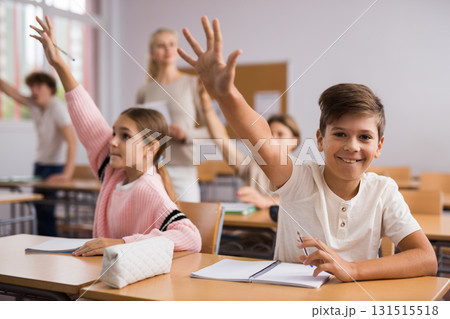 Students raise their hand to answer during lesson in class 131515518