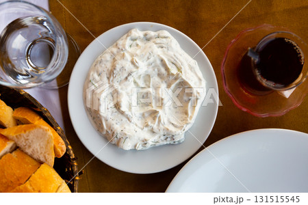 Plate with cacik, yogurt sauce with shredded cucumber, greens and garlic Plate with cacik, yogurt sauce with shredded cucumber, greens and garlic 131515545