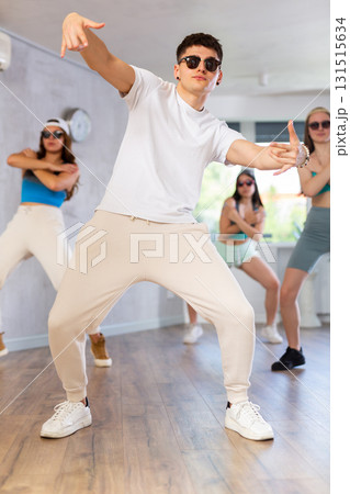 Expressive guy krump dancer dancing with teenagers in studio Expressive guy krump dancer dancing with teenagers in studio 131515634