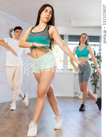 Girl teen perform choreographic exercise and teach energetic mobile social dance vogue with friends Girl teen perform choreographic exercise and teach energetic mobile social dance vogue with friends 131515637