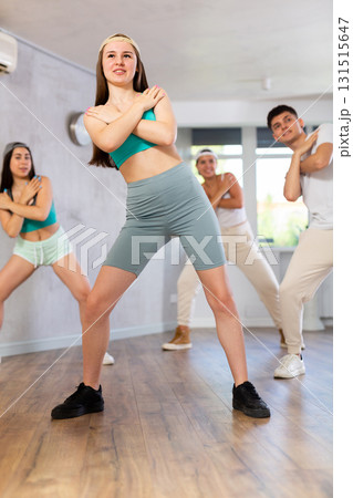 Young girl in ball cap and teenagers actively move and dance hip hop at choreography lesson 131515647