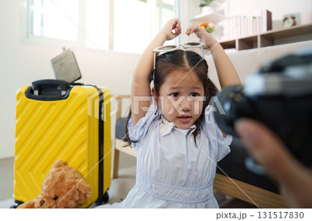 Family Travel. Child posing with sunglasses while preparing for a trip. Family Travel. Child posing with sunglasses while preparing for a trip. 131517830