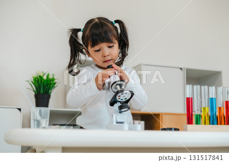 happy toddler girl scientist learning science with microscope 131517841