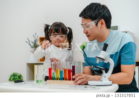 toddler girl scientist study using pipette dropping liquid with test tube and beaker. learning science with father 131517851