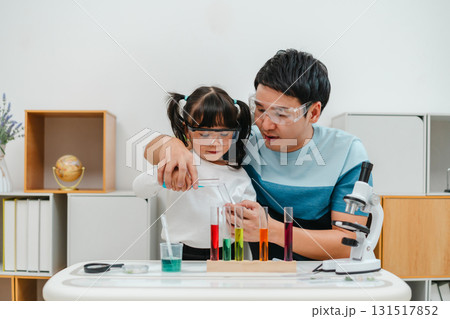 father and toddler girl scientist making chemical test with test tube. learning science father and toddler girl scientist making chemical test with test tube. learning science 131517852