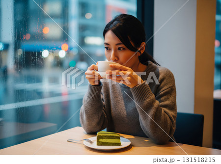 雨降るカフェでくつろぐ女性:抹茶ケーキと温かい一杯で過ごす癒しのひととき 雨降るカフェでくつろぐ女性:抹茶ケーキと温かい一杯で過ごす癒しのひととき 131518215
