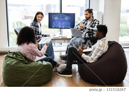 Diverse team of young adult men and women working on car design blueprint project. 131518267