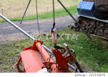 チェーンで吊り上げられる農機具のクローズアップ 131518875