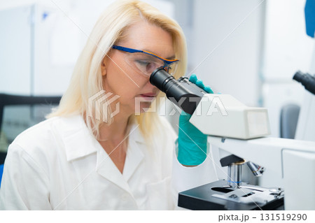 Laboratory researcher performing microscopic analysis for disease detection and medical innovation studies Laboratory researcher performing microscopic analysis for disease detection and medical innovation studies 131519290